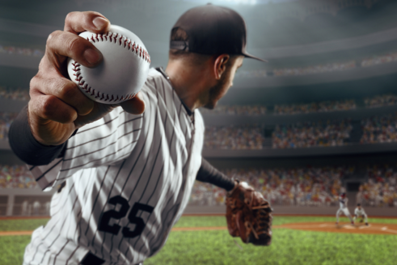 Baseball pitcher throws the ball in professional baseball stadium.