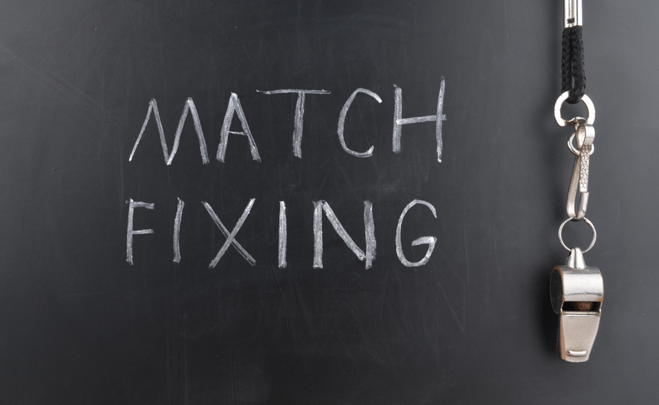 "match fixing" written on chalkboard with whistle