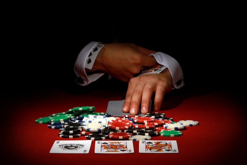 Man with cards up his sleeve in poker game