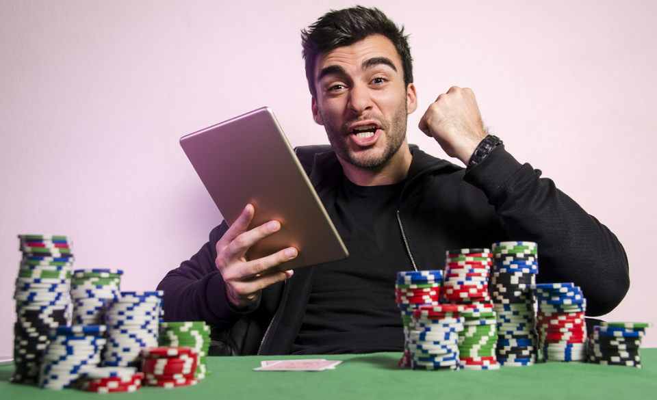 ecstatic man with tablet playing online poker