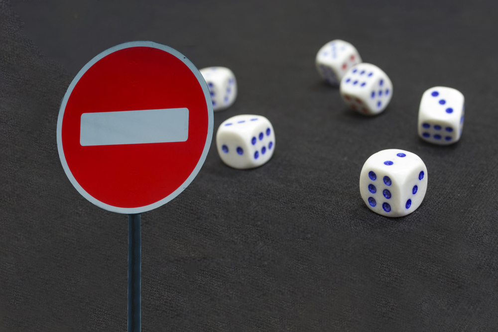 one-way sign with dice in the background, indicating a gambling ban