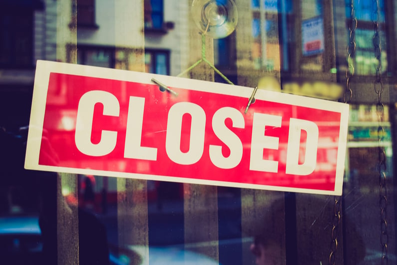 Closed sign hanging in store window