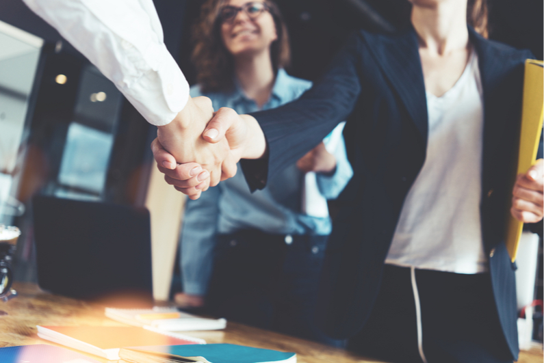 Businesswoman shaking hands with businessman