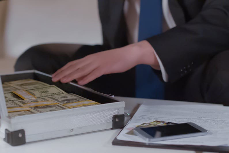 Businessman looking at cash in a briefcase