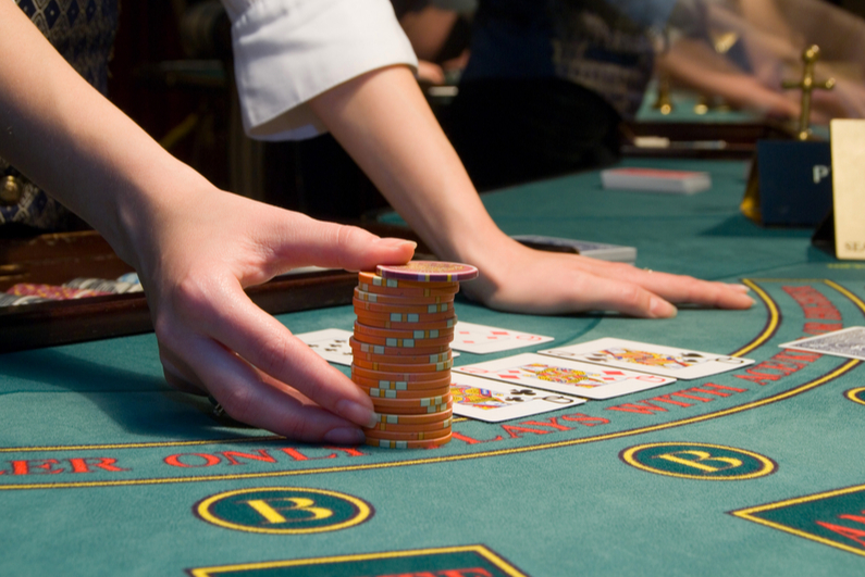 closeup of casino dealer handling stack of chips