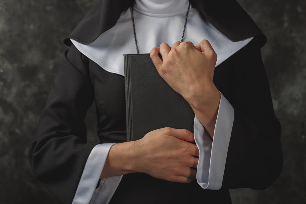 nun holds book in hands