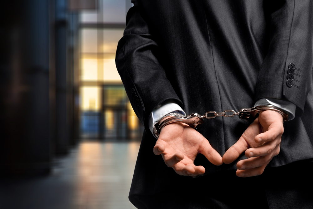 man in suit with handcuffed wrists