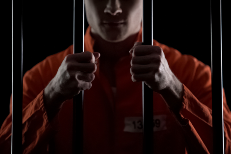 Man holding prison bars